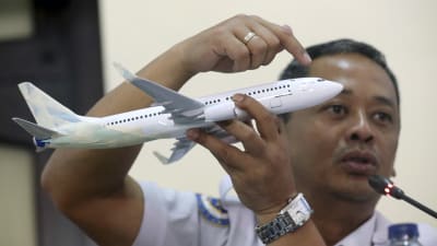 Olycksutredaren Nurcahyo Utomo håller en miniatyr av ett Boeing 737 MAX-plan under en presskonferens om Lion Airs flygolycka.den 28 november.
