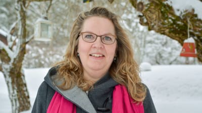 Annika Gustafsson-Flinck utomhus under vintertid. I bakgrunden syns träd och mark täckt av snö. 