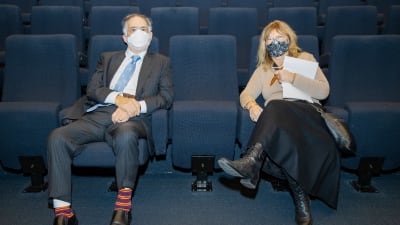 Francis Ford Coppola och Annika Hällsten sitter i en biosalong. Båda har ansiktskydd på sig och sitter några bänkar isär från varandra.