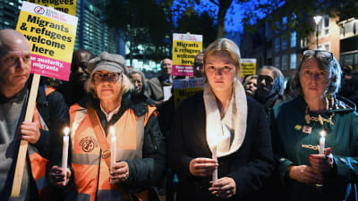 Personer håller i ljus och demonstrerar för flyktingar i London.