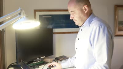 En man skriver på sin dator.