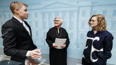 Paul Tiensuu och Emilia Korkea-aho överlämnade rapporten till kommun- och reformminister Anu Vehviläinen (C) i Helsingfors i dag.