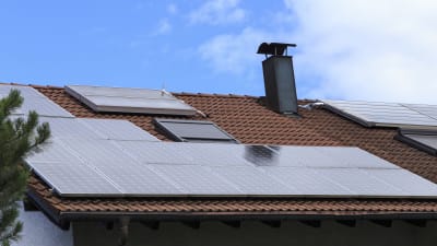 Ett hus med en massa solpaneler på taket.