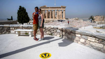 Ett par tog en selfie framför Parthenon-templet på Akropolis-klippan den 18 maj. På grund av coronakrisen finns märken på klippan som ska underlätta social distansering. 