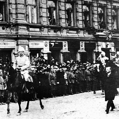 Mannerheim rider på en häst i en stad.