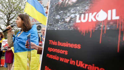 kvinna i ukrainsk flagga protesterar mot Lukoil i Bryssel