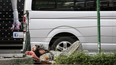 Hemlös kvinna sover på gatan i Thailands huvudstad Bangkok 25.2. 2015.