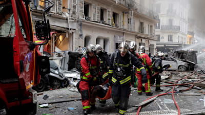 Brandmän bär bort en skadad person efter lördagens explosion i centrala Paris. 