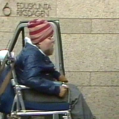 Kalle Könkkölä i rullstol utanför Riksdagshuset, 1983