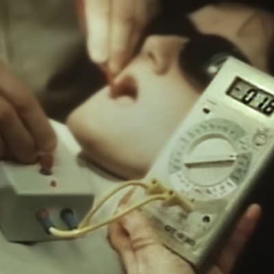 En tandläkare mäter ström i munnen på en patient