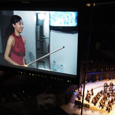 Nancy Zhou viilettää lavalle soittamaan Tshaikovskin viulukonserton ensimmäisessä finaali-illassa 1.12.2015.