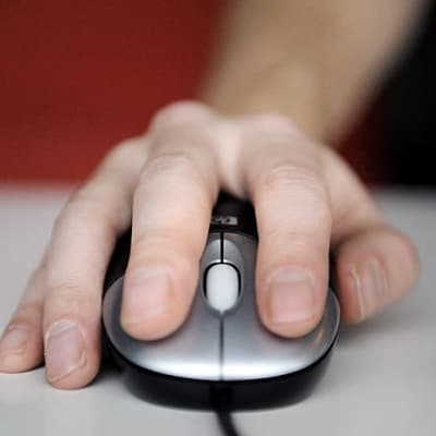 Käsi on tietokoneen hiirellä.