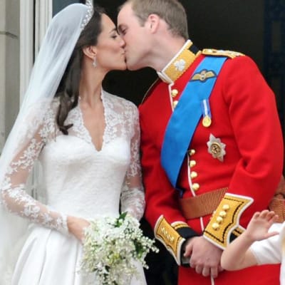 Vastavihityt herttuatar Catherine ja prinssi William suutelevat Buckinghamin palatsin parvekkeella.