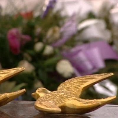 Lähikuva arkun päällä olevista lintukoristeista