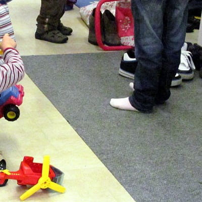 Lapsi leikkii lattialla leluilla.