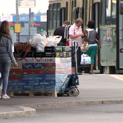 Nainen Länsisatamassa lavallisen alkoholijuomia kanssa.