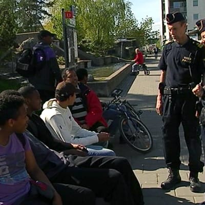 Poliisipartio keskustelee paikallisten asukkaiden kanssa Husbyn lähiössä.