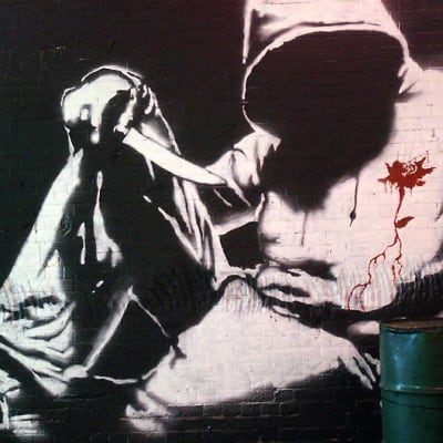 Alikulkutunneliin tehty Banksyn graffitimaalaus, jossa on veitseä pitelevä hupparimies.
