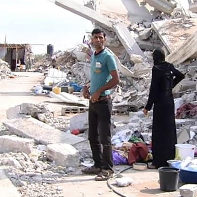 Palestiinalaisperhe tuhotun talon vierellä Gazan kaistalla.