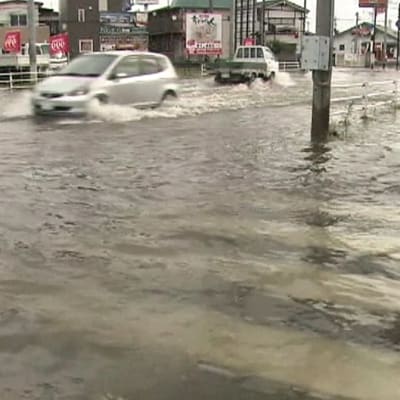 Autot ajavat tulvivalla kadulla.