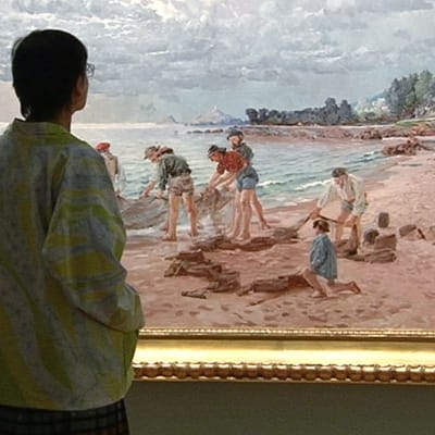 Näyttelyvieras katselemassa August Uotilan maalausta Amos Andersonin taidemuseossa.
