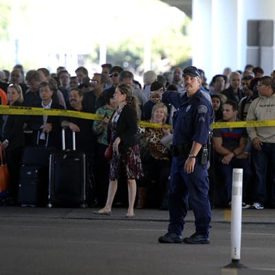 Matkustajat odottavat pääsyä takaisin terminaaliin ampumavälikohtauksen jälkeen Los Angelesin lentokentällä.