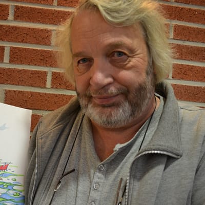 Heikki Eklöf piirtää kuvansa nopeasti. Kuvassa wenkoolit piirroshahmot ovat kalassa