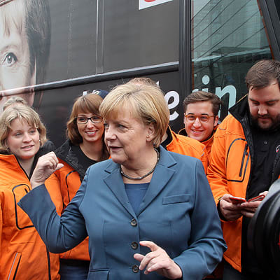 Saksan liittokansleri Angela Merkel esittelee CDU-puolueensa kampanjabussin puolueen päämajan edustalla.