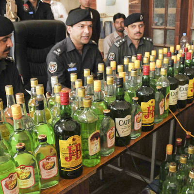 Pakistanin poliisi esittelee takavarikoimiaan alkoholipulloja.