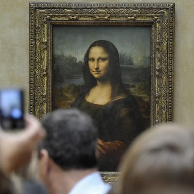 Ihmiset tungeksivat Mona Lisan edustalla Louvren taidemuseossa.