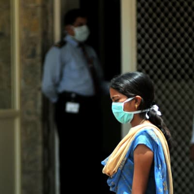 Ihmiset suojasivat kasvonsa hengityssuojilla St. Philomenan sairaalassa, Intian Bangaloressa, elokuussa 2009. Kuvanottopäivänä sairaalassa menehtyi sikainfluenssaan kaupungin ensimmäinen taudin uhri. 
