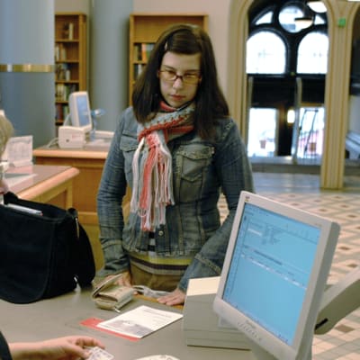 Kirjastonhoitaja ja asiakas Richardinkadun kirjastossa Helsingissä.