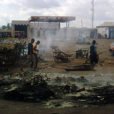 Kristittyjen kostoksi polttaman bensa-aseman jäänteet savuavat Kadunassa 17. kesäkuuta.