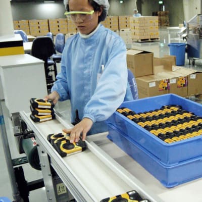 Työntekijä valmistaa kertakäyttökameroita Eastman Kodakin tehtailla Kiinassa, Xiamenissa vuonna 2004.