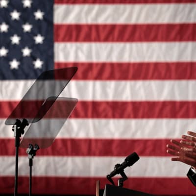 Barack Obama puhumassa suuren Yhdysvaltojen lipun edessä.