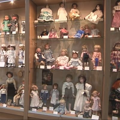 Nukkemuseo Suruttoman nukkeja esillä vitriineissä.