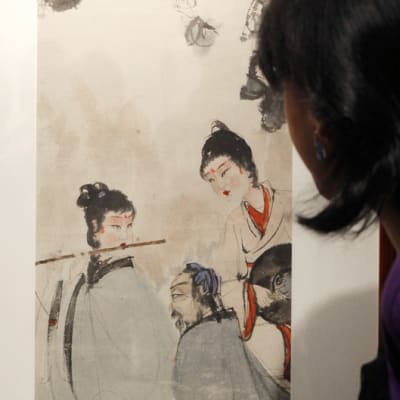 Nainen tutkii kiinalaisen taiteilijan Qi Baishin teosta huutokauppakamari Sotheby'sin  tiloissa Hongkongissa.