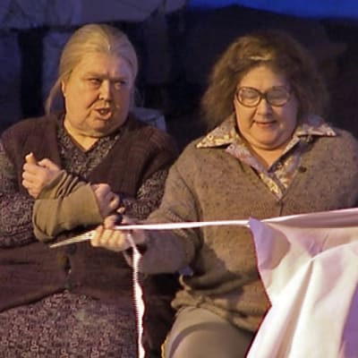 Kaksi vanhaa naista istuu penkillä näyttämöllä