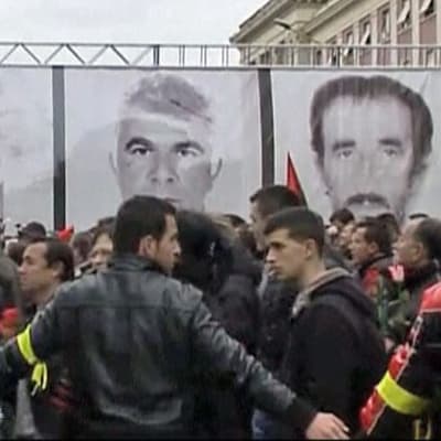 Albanialaisia mielenosoittajia kuolleden mielenosoittajien kuvien edessä