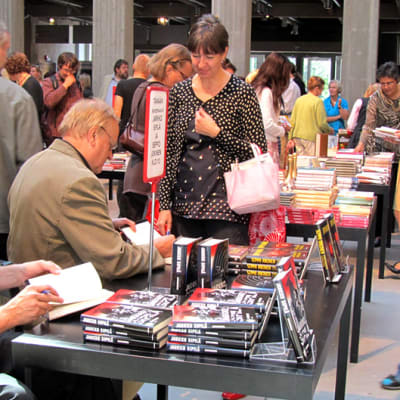 kirjallisuustapahtumassa kirjailijat signeeraavat kirjoja