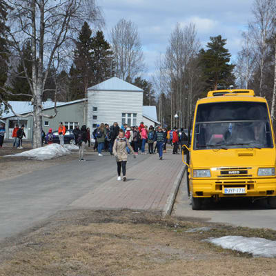 Koululaisia kävelemässä koulukuljetuksen kyytiin Simon Asemakylän koululla.