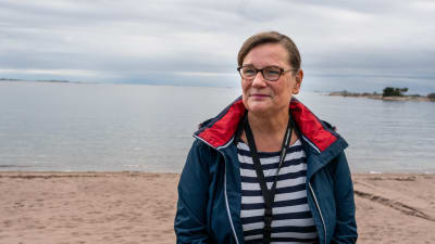 Elisabeth Kajander med havet och sandstrand i bakgrunden.