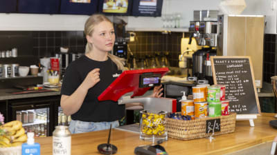 En tjej som står i kassan och jobbar på Cafe Carusel.