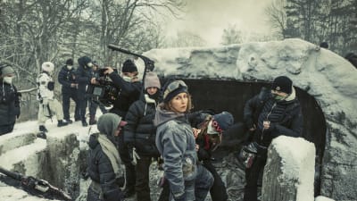 På bilden syns en grupp människor vid en skyttegrav.