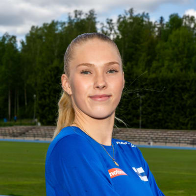 Jessica Kähärä seisoo urhelukentällä ja katsoo kameraan.