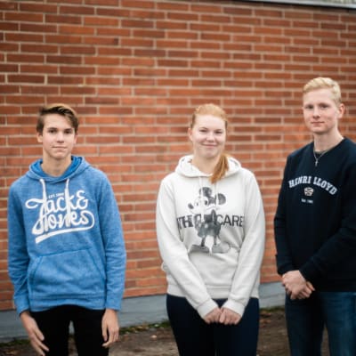 Tre studerande står framför en tegelvägg. Samuel Berg (t.v.), Rebecca Sandfors och Robin Forsman.
