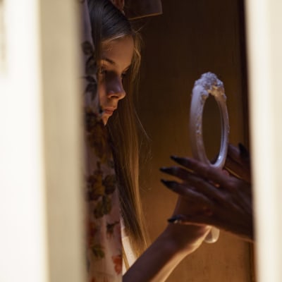 Huvudrollsinnehavaren Tinja ser sig i spegeln i den finska skräckfilmen Ruva.