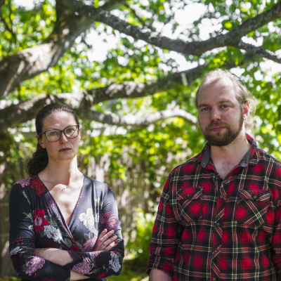 Linda Siik (t.v.) och Jesse-Pekka Rautiainen under ett träd på gården av deras hem i Marudd i Helsingfors.