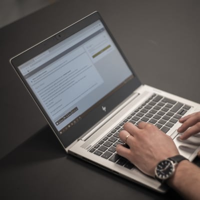 En person använder en bärbar dator och är inne på webbtjänsten Wilma.