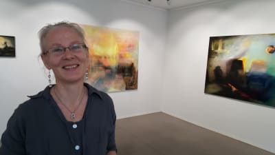 Margareta von Bonsdorff framför två av sina målningar på Galleri Bronda 2016.